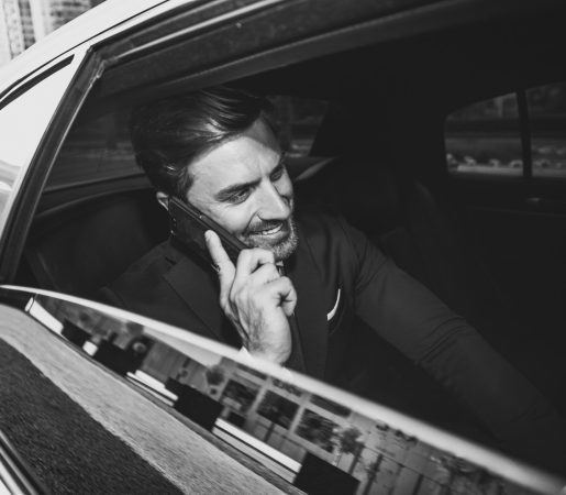 Businessman in Limousine – Miami Premier Transportation Executive Service Businessman sitting in the back of a luxury limousine, enjoying Miami Premier Transportation's executive chauffeur services